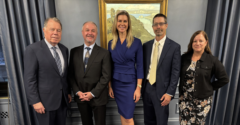 group of business men and women posing together