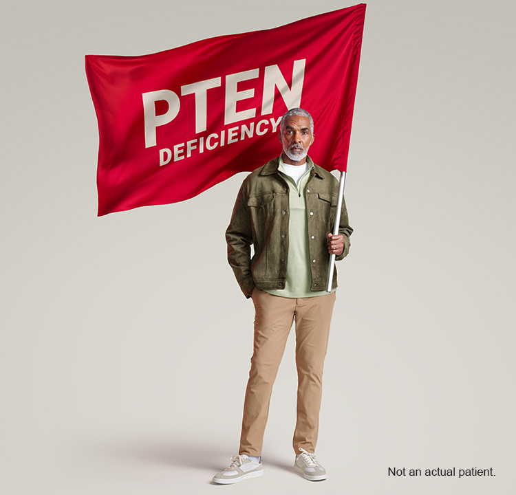 Person standing and holding the PTEN Deficiency red flag