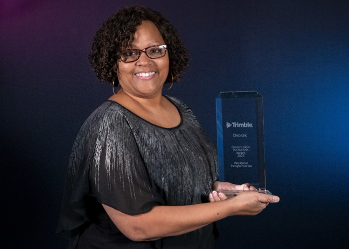 Headshot of a woman proudly holding a 'Trimble Dvorak Construction Innovation Award 2023 for Workforce Transformation'.