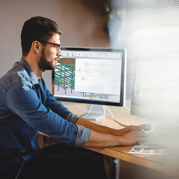 A structural engineer using Tekla software to design a complex 3D steel and concrete building frame.
