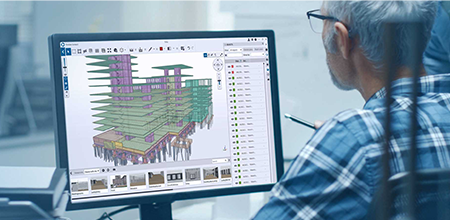 Konstrukteur sitzt vor Bildschirm auf dem ein 3D-Modell in Trimble Connect zu sehen ist.