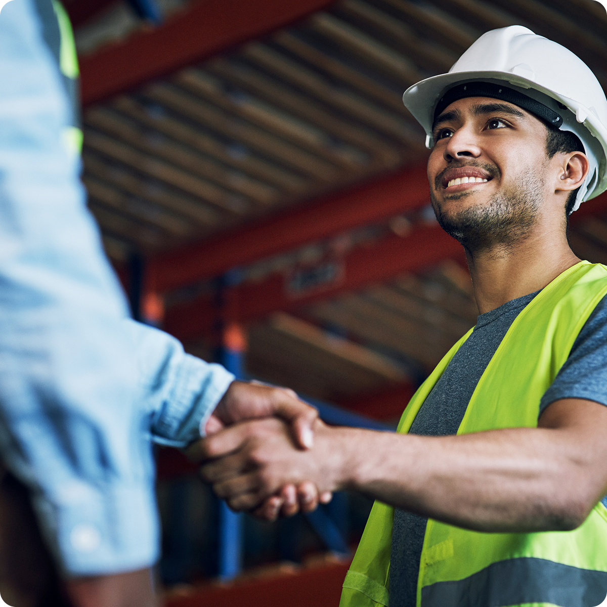 Field construction worker smiling and shaking hands with a colleague