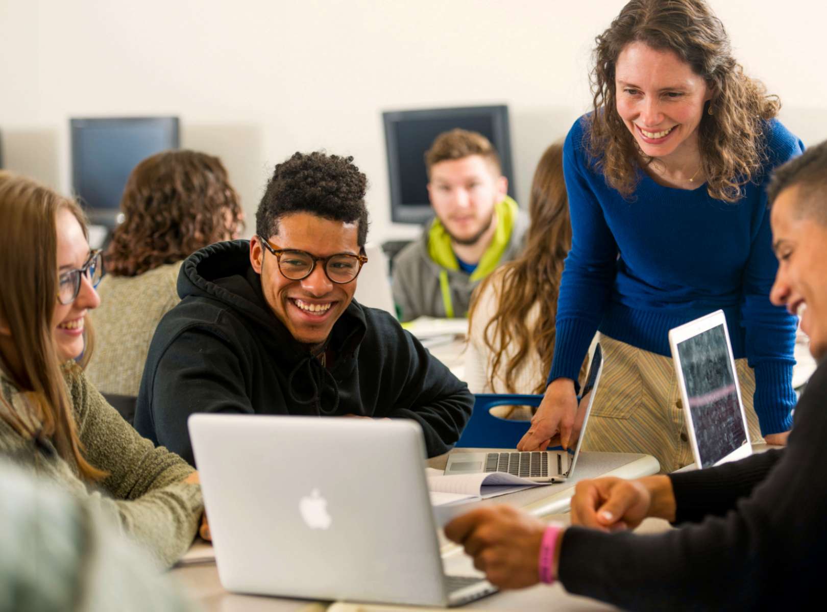 Students and professor working on laptops