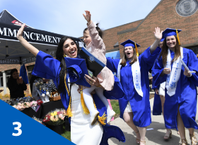 Students celebrating graduation with one holding a child