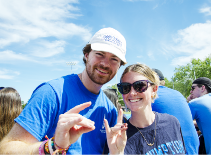 Students forming a dog with their hands and smiling at camera.