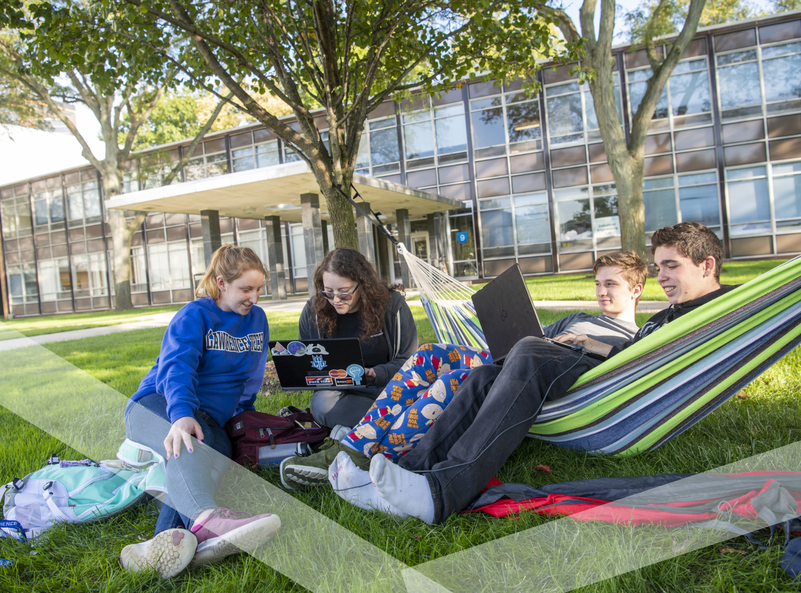 Students in hammocks working on laptops.
