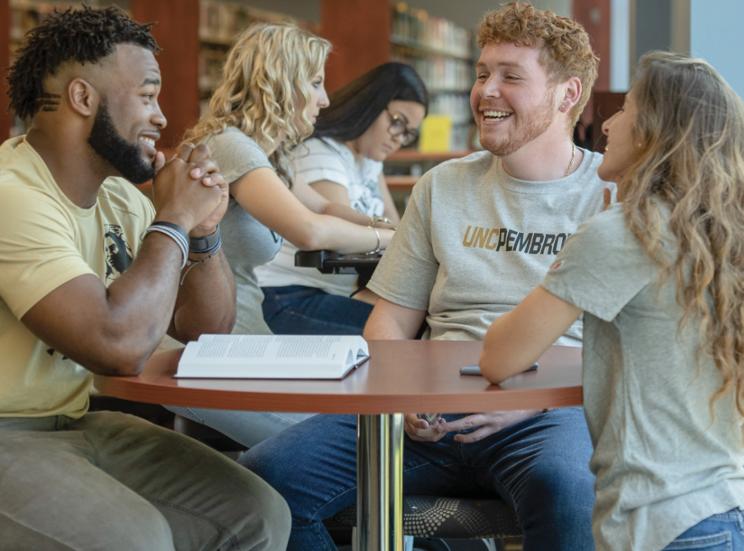 Students sitting at a table and talking.