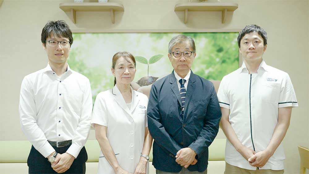 4人のプロフェッショナルがカメラに向かって並び立っている様子。背景には新芽の絵が描かれている。