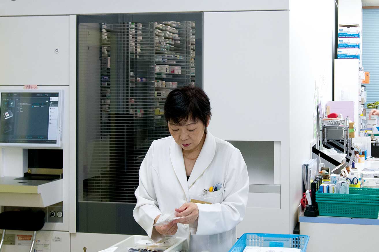 薬局で薬剤を扱う女性薬剤師。