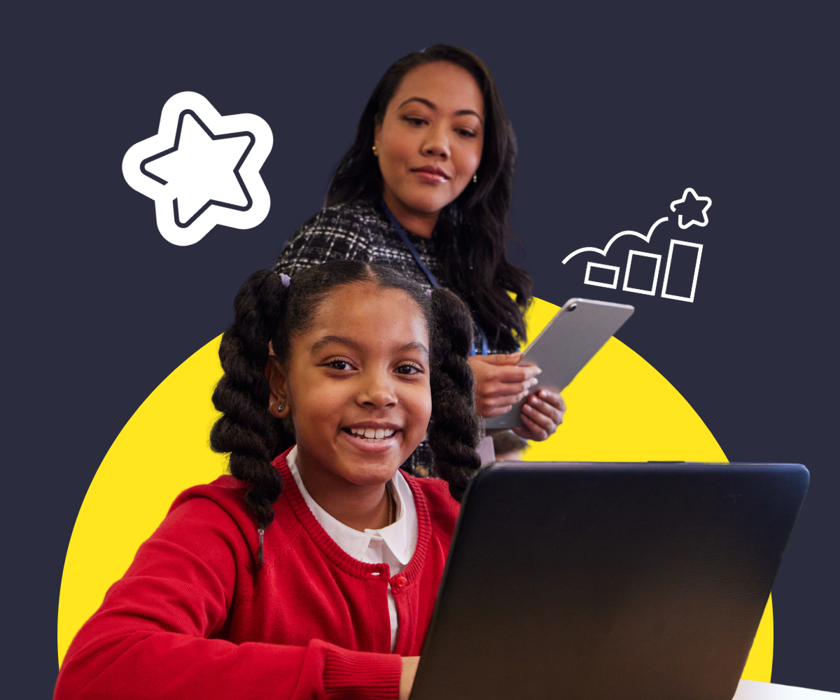 Smiling schoolgirl in a red cardigan uses a laptop while a teacher stands behind her holding a tablet.