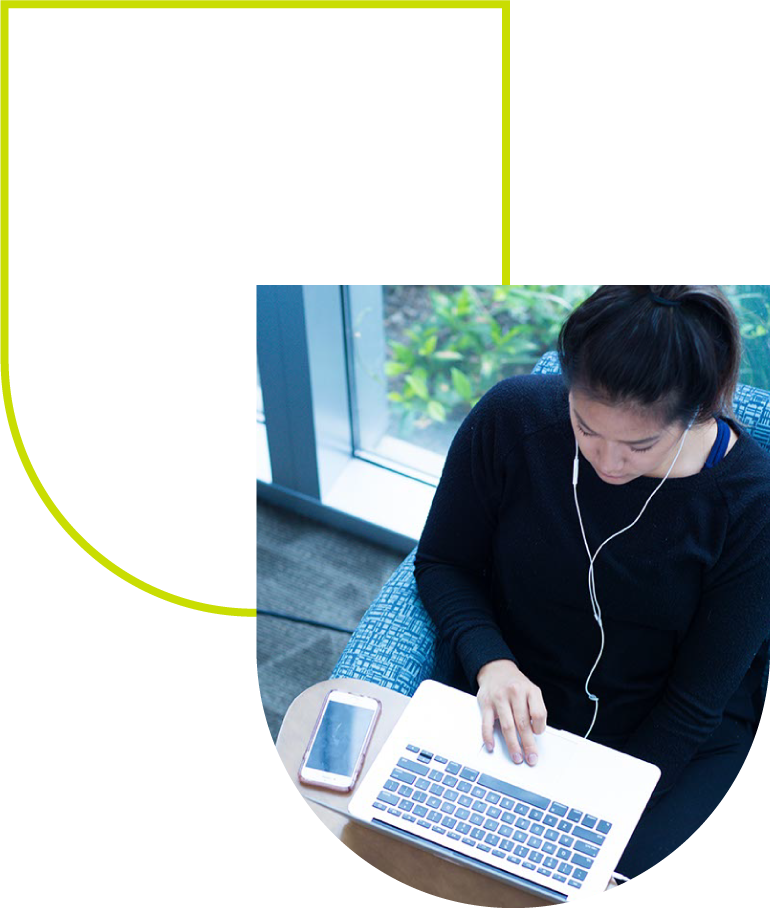 Young professional studying on a laptop and phone, representing the future of physical therapy at the University of St. Augustine for Health Sciences.