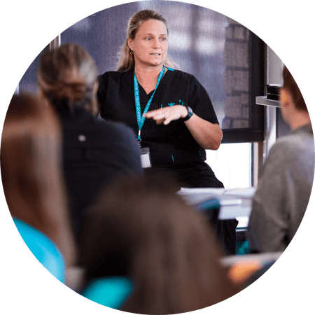 A healthcare professional or trainer leads a discussion, actively engaging with attendees.