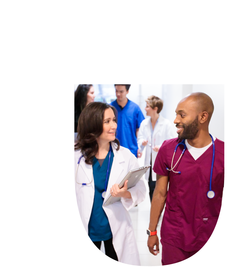 Smiling healthcare professionals, a woman in a lab coat and a man in scrubs, walking forward, suggesting progress in a family nurse practitioner career.