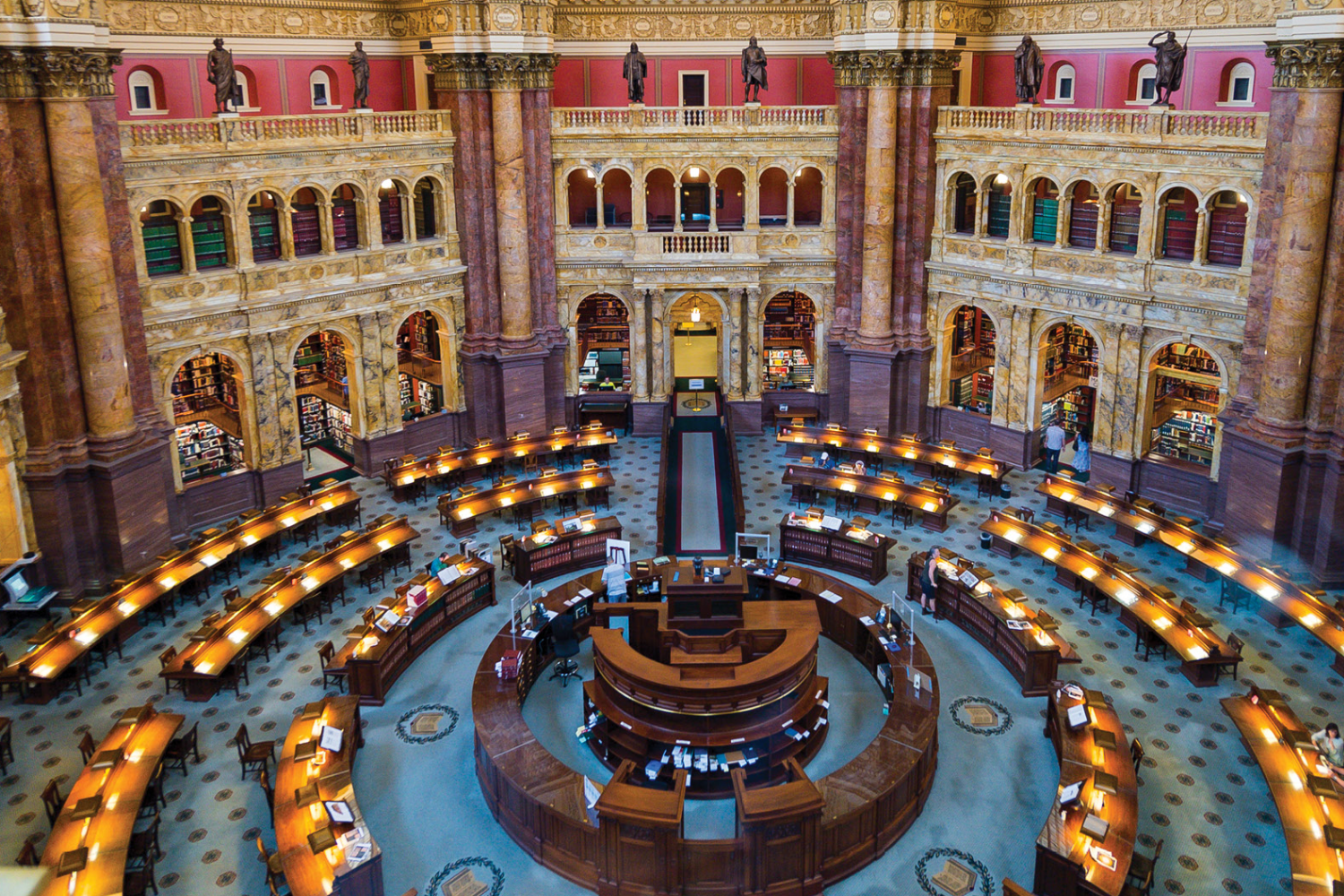 A woman is sitting at a desk using a tablet