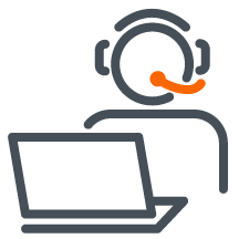 A woman sitting at a desk talking on a cell phone in front of a laptop