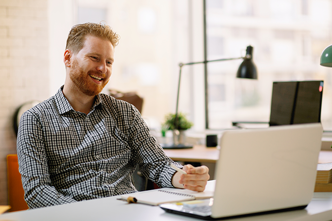 A professional working from home, happily engaged in a video conference.
