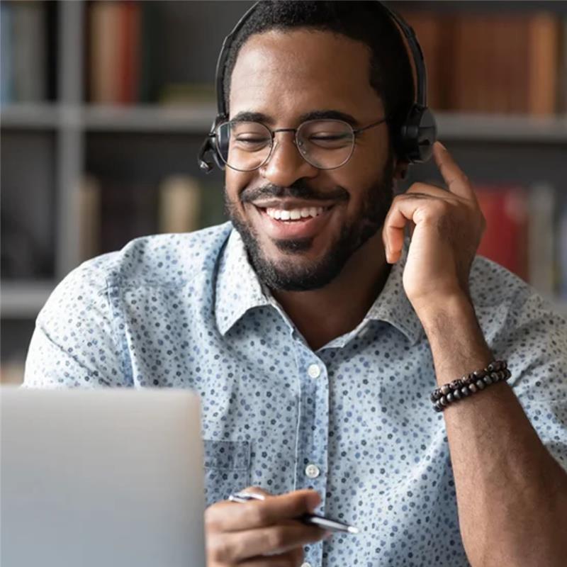 Man with headphones participating in a webinar and smiling
