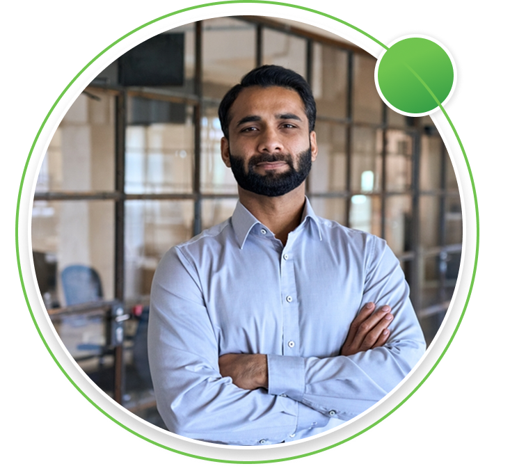 Three professionals in a modern office meeting room, with a man leading a discussion in front of a glass board displaying business charts.