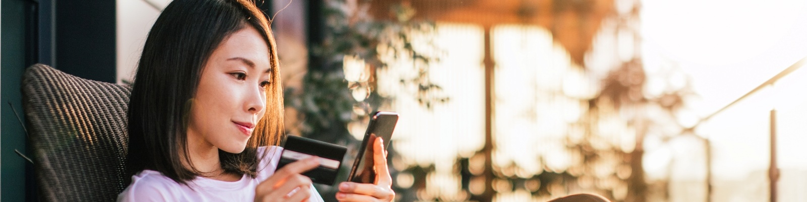 A woman looking intently at her phone screen, sitting and relaxing