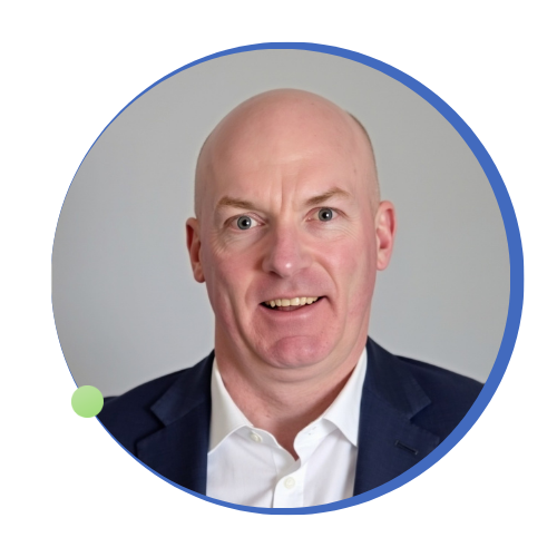 Headshot of a bald man smiling, wearing a dark suit jacket and white shirt.